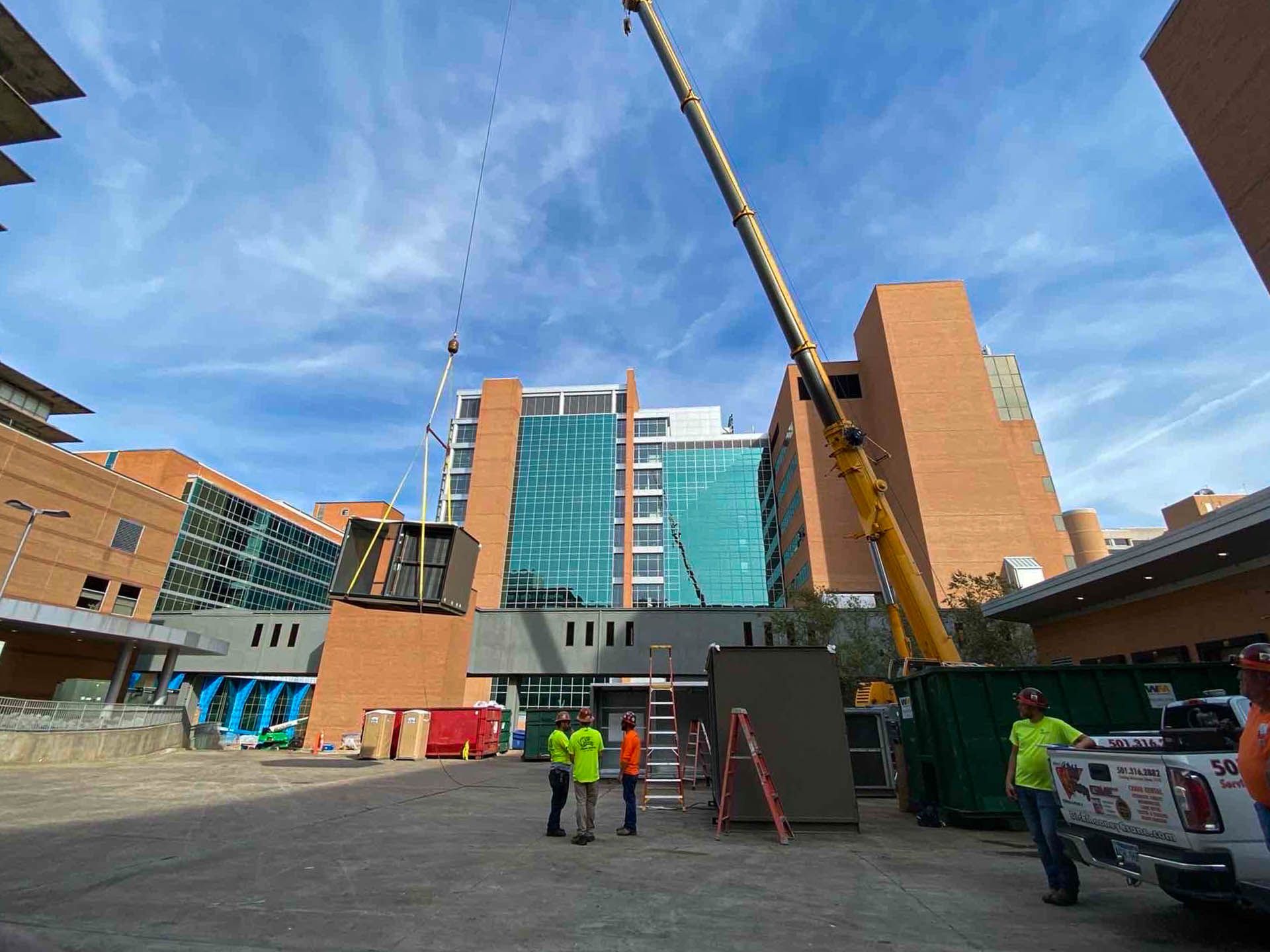 A group of construction workers are standing in front of a large building.