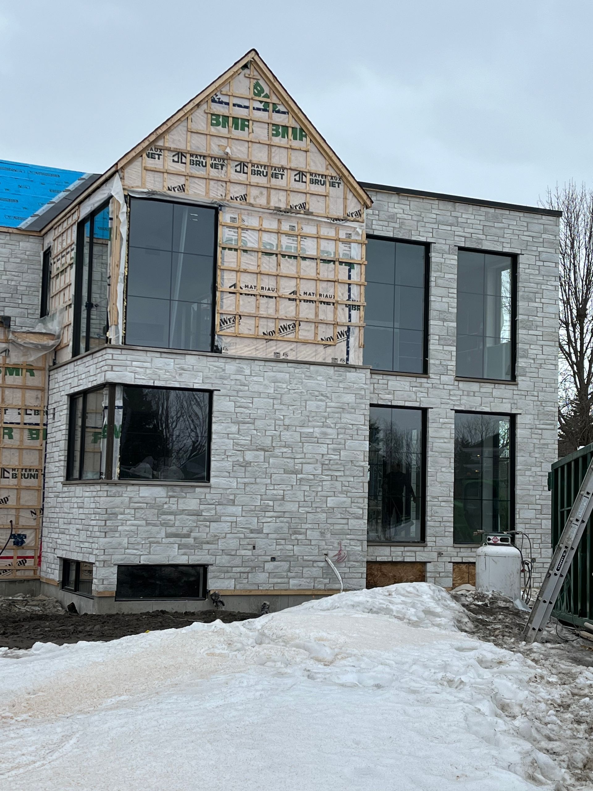 Une grande maison en briques blanches est en construction dans la neige.