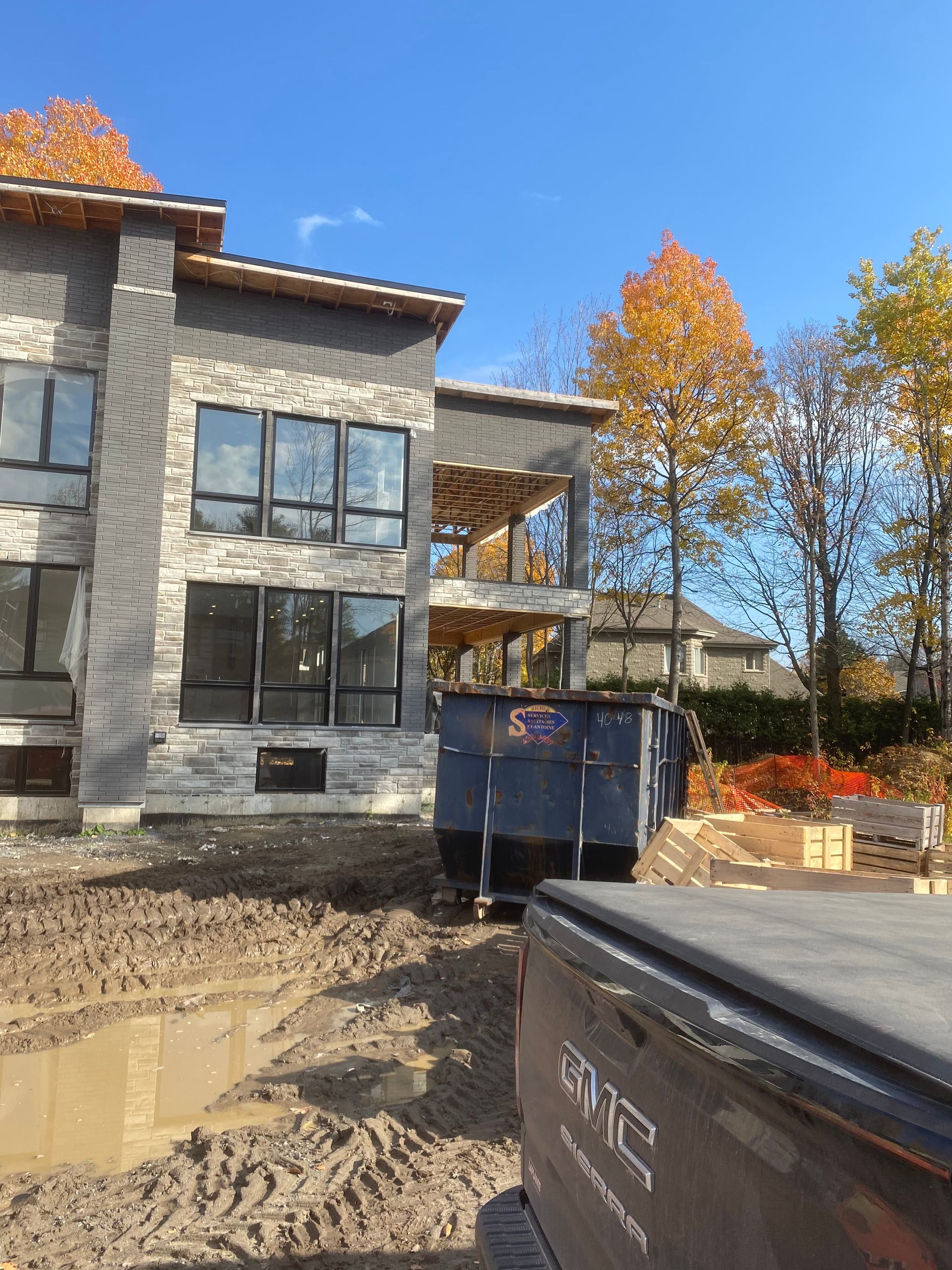 Un camion est garé devant une maison en construction