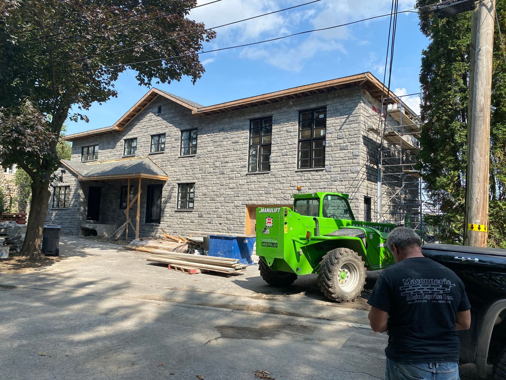 Un tracteur vert est garé devant un grand bâtiment en pierre.