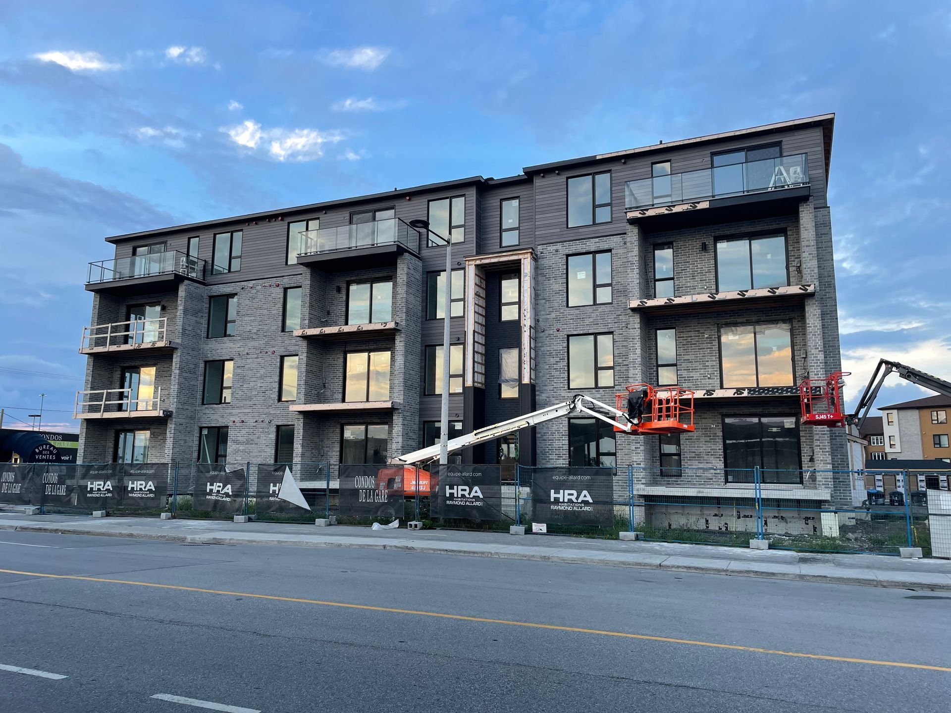 Un grand immeuble en construction avec une grue devant lui.