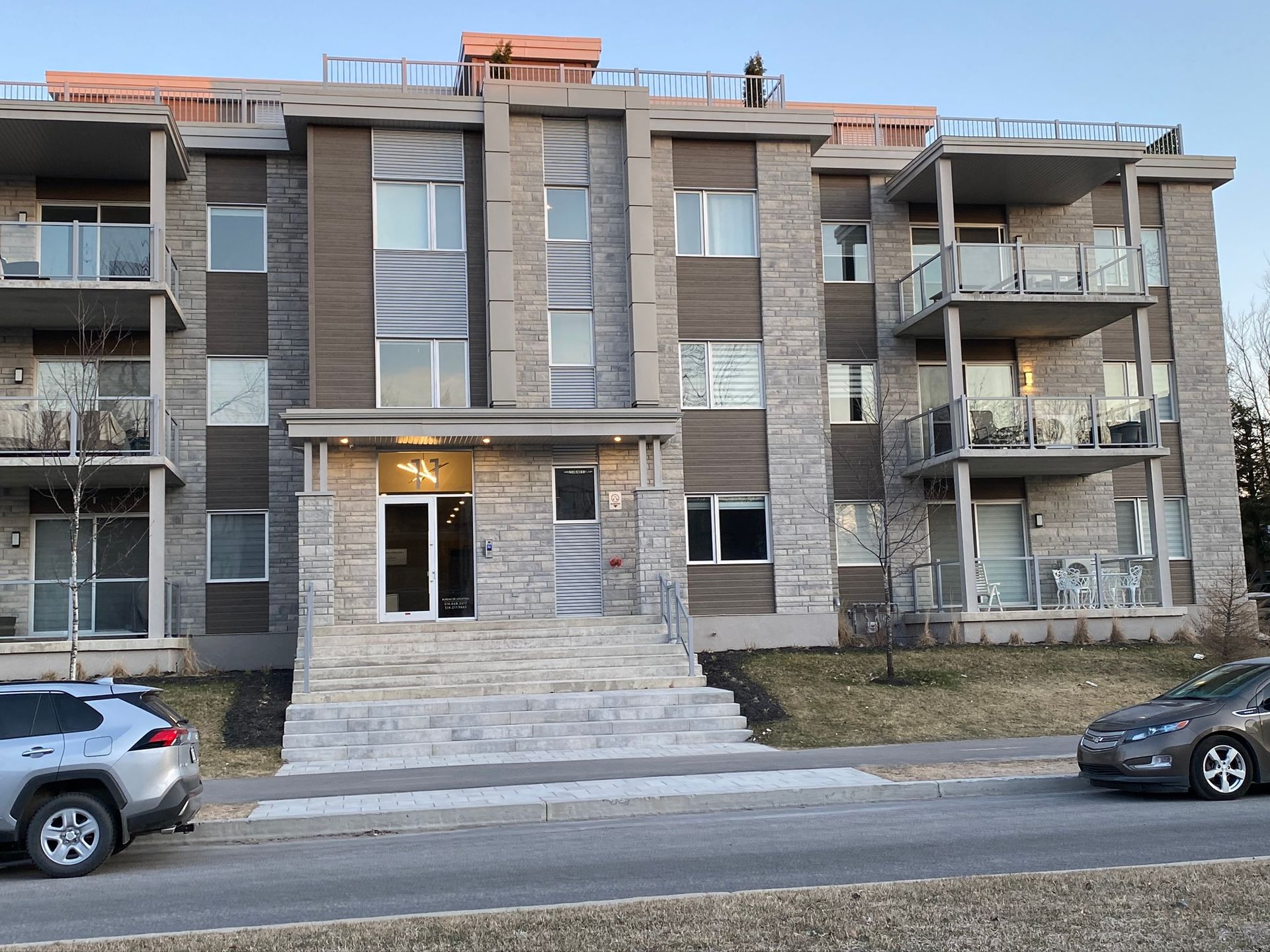 Un grand immeuble avec des voitures garées devant