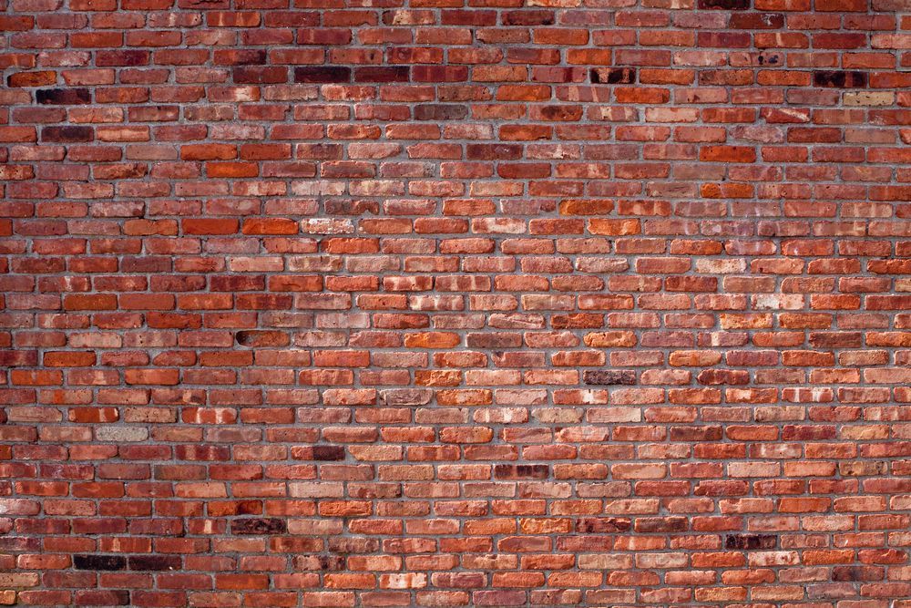 Un gros plan d'un mur de briques rouges avec beaucoup de briques