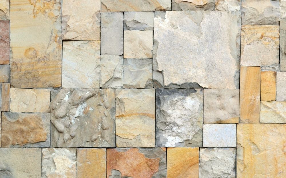 Un gros plan d'un mur de pierre fait de carreaux carrés.