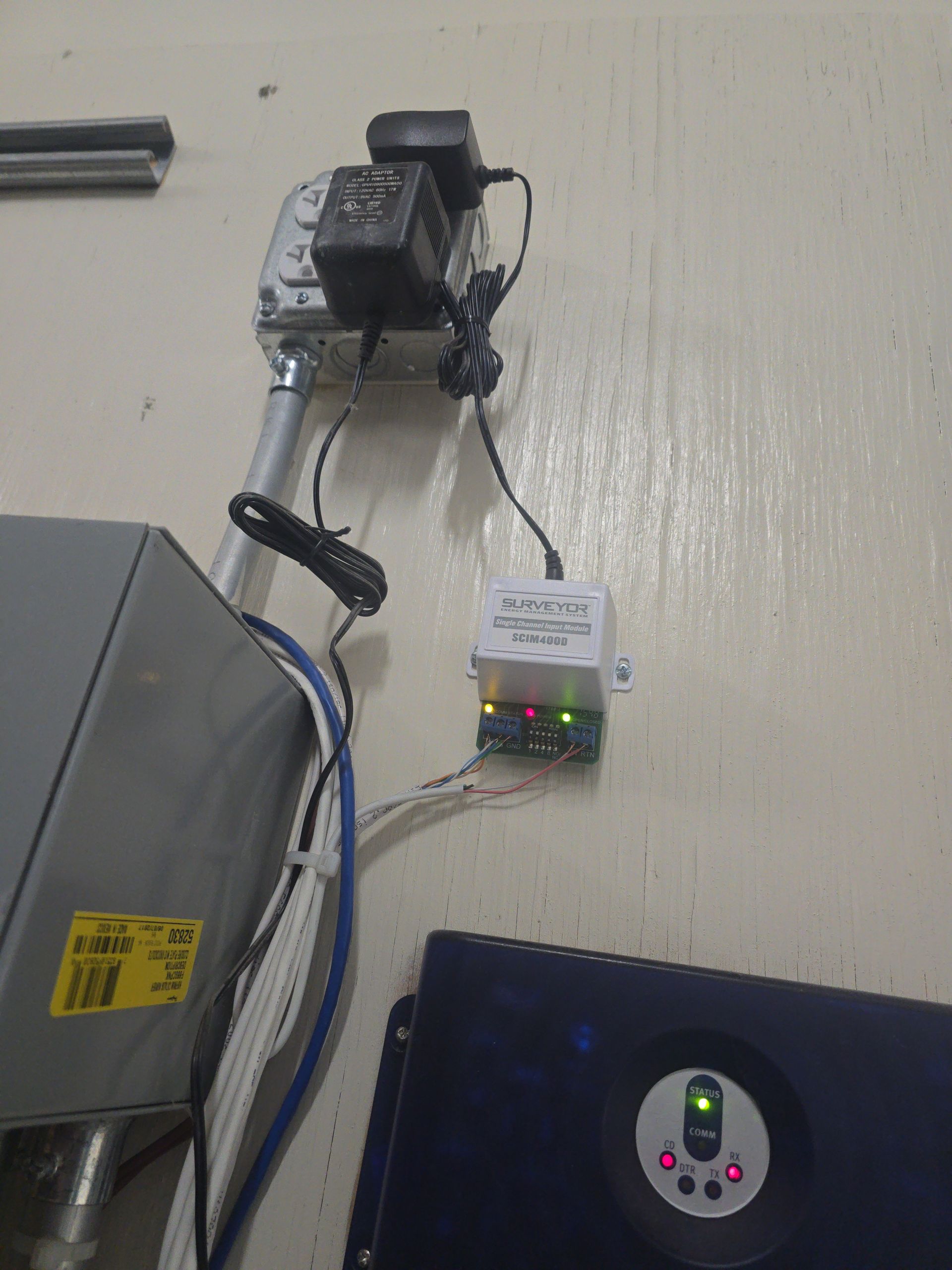 Electrical components mounted on a wall; includes boxes, power supplies, and wiring.