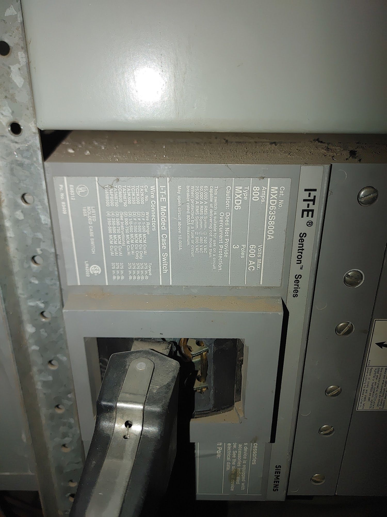 Circuit breaker panel with gray label, black cable.