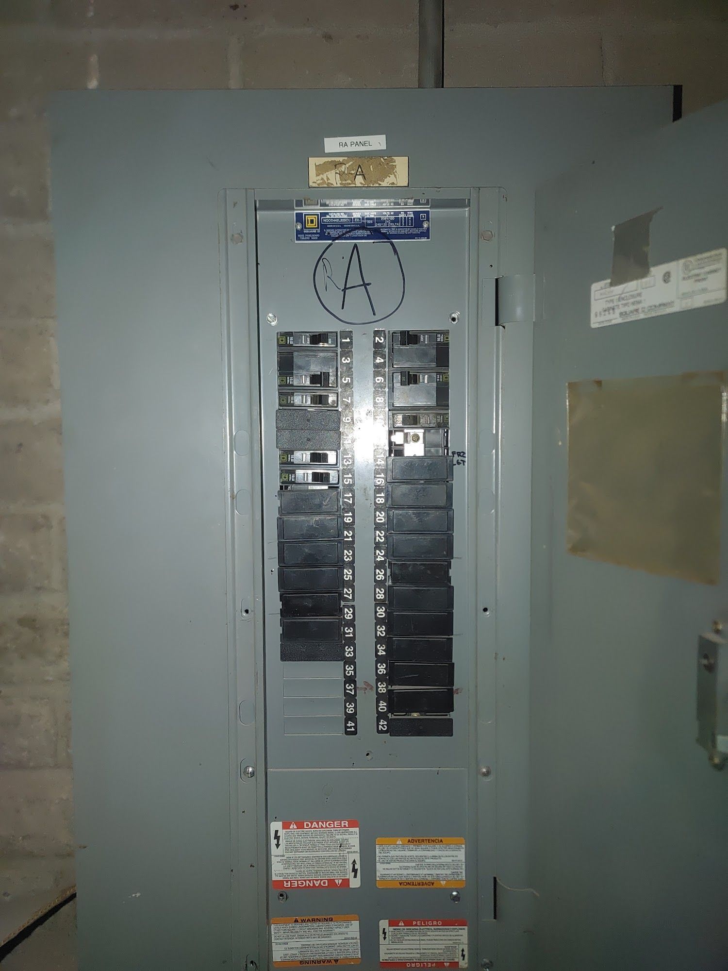 Gray electrical panel with circuit breakers labeled 