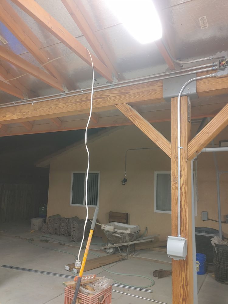 Electrical wiring running overhead in a covered outdoor area.
