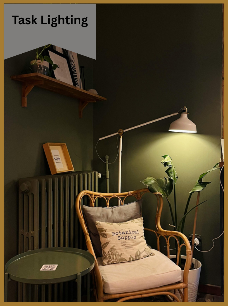 A green room with a chair, table, task lamp and radiator.