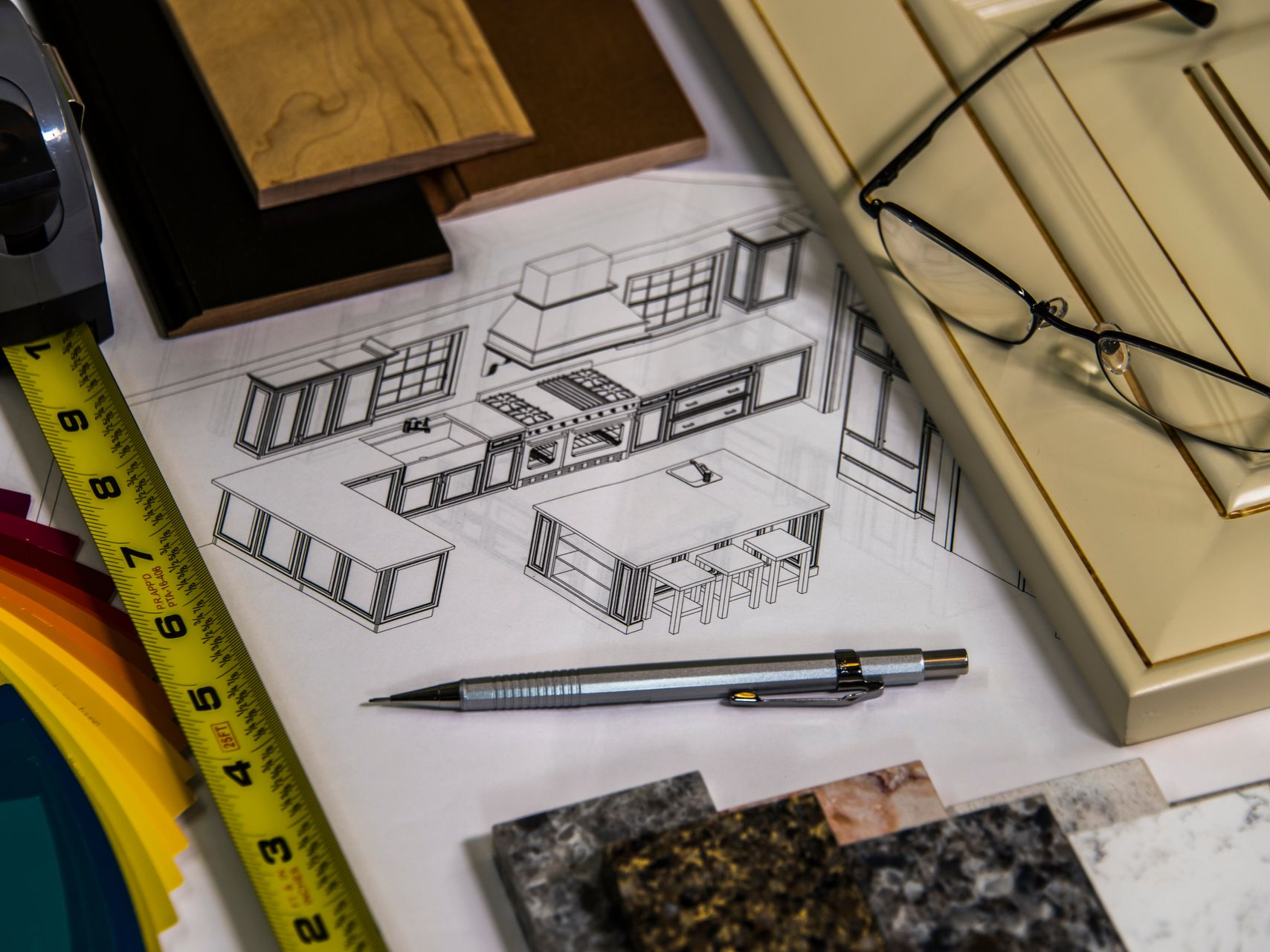 Kitchen design plan with materials, pen, glasses, and color swatches.