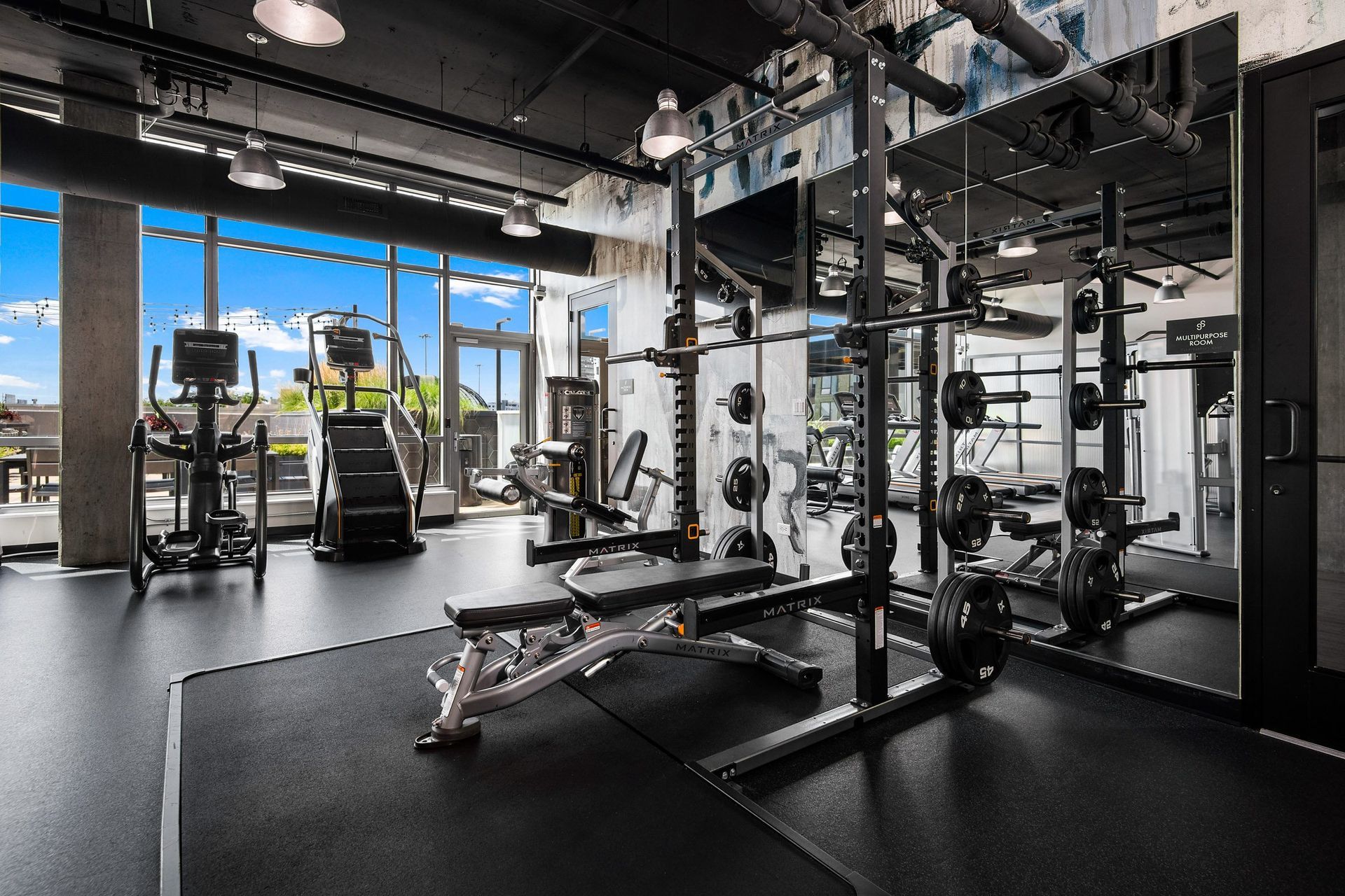 a gym with weights and other exercise equipment and a window