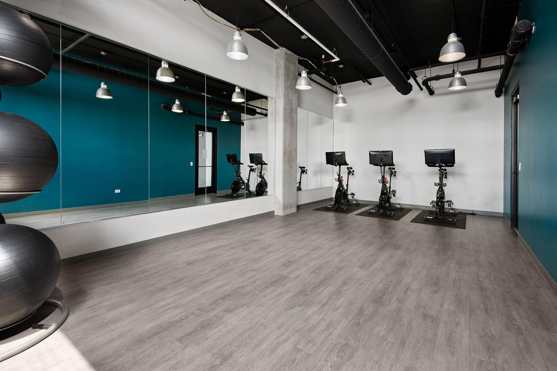 a fitness room with exercise machines and a large mirror