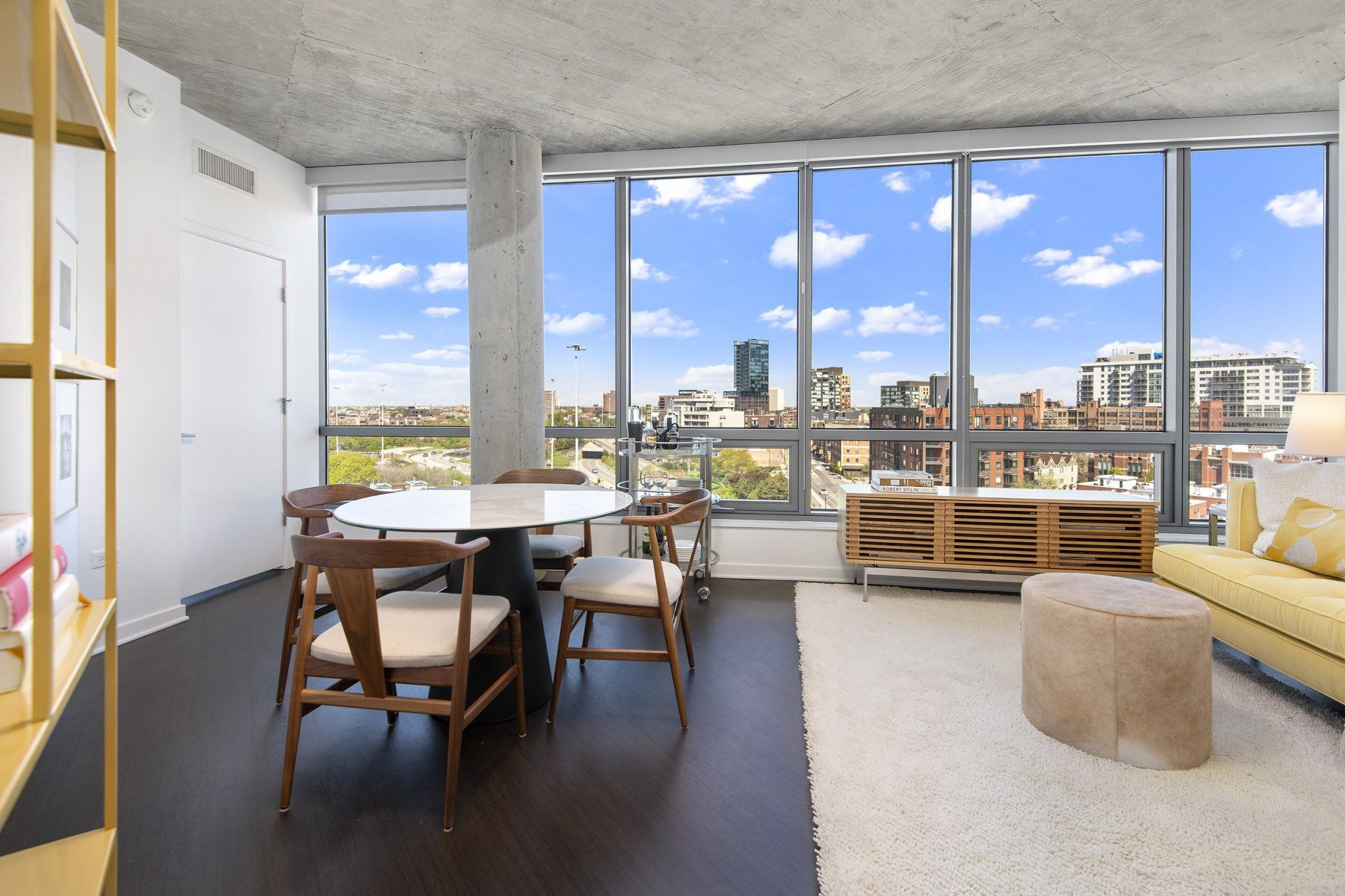 A living room with a table and chairs and a view of the city at Reside on Green Street.