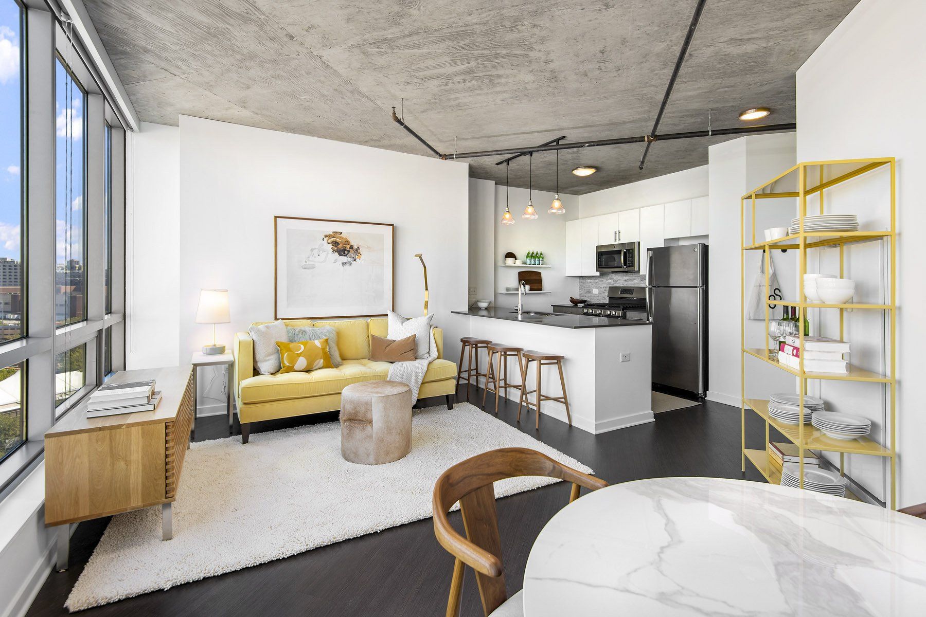 Modern apartment with yellow decor and floor to ceiling windows at Reside on Green Street.