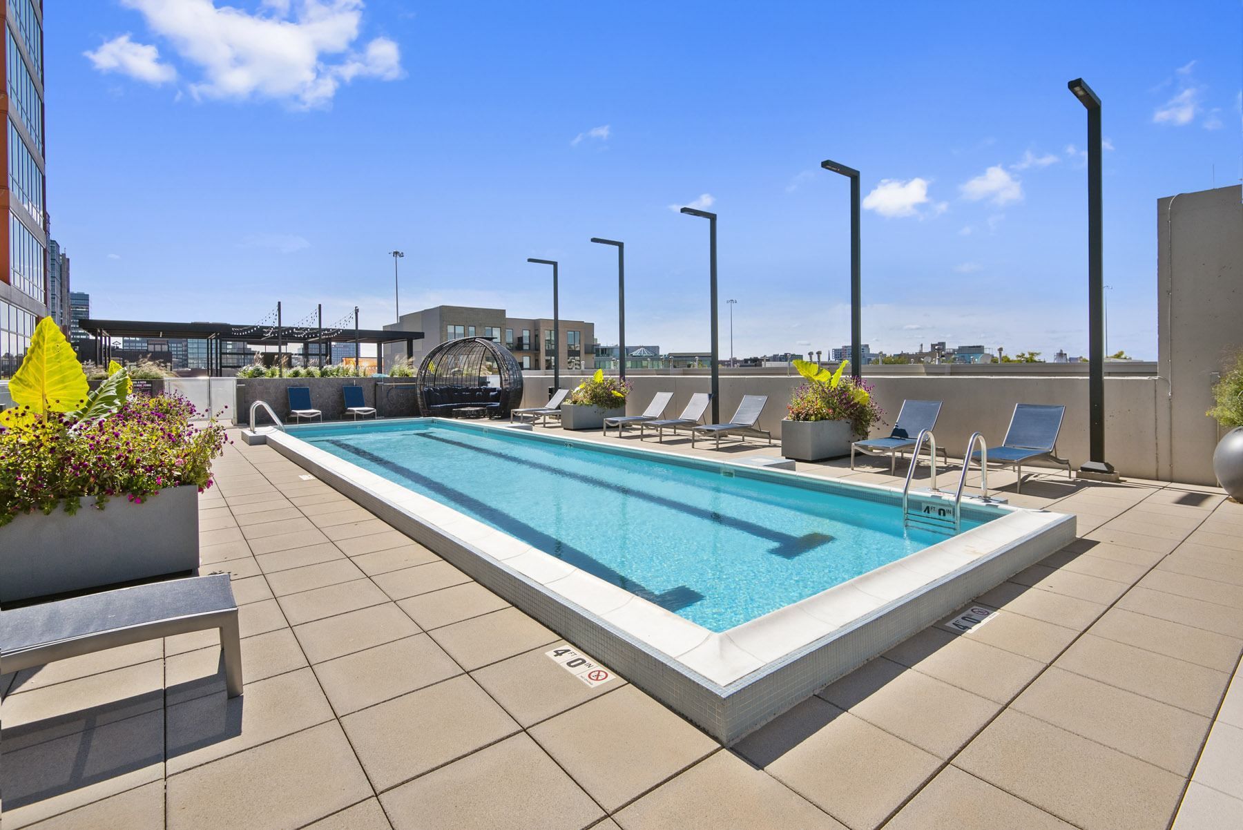 the pool on the rooftop of a building with lounge chairs