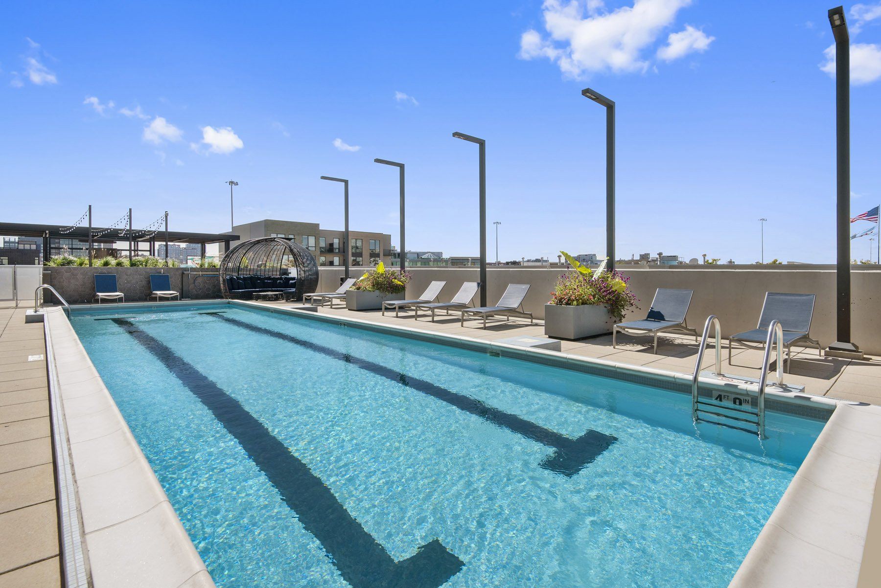 A large swimming pool with chairs and umbrellas around it at Reside on Green Street.