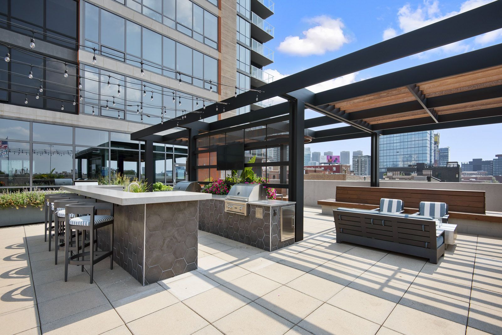 a rooftop patio with a bar and a city skyline