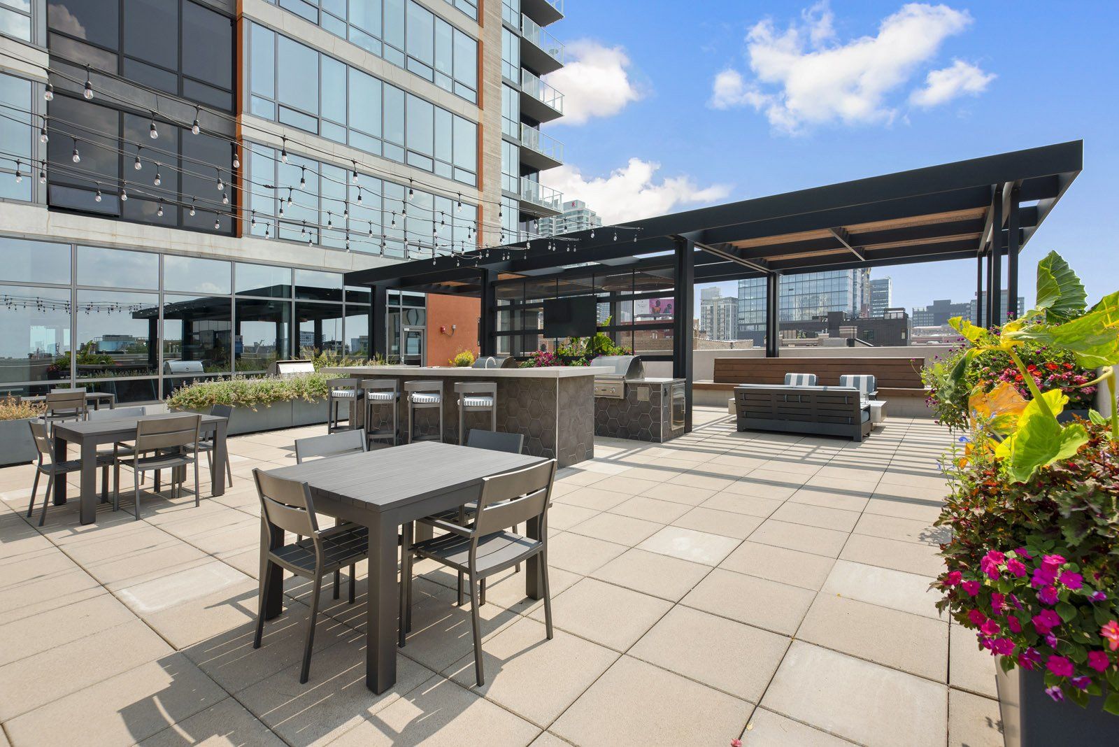 A patio with tables and chairs in front of a building at Reside on Green Street.
