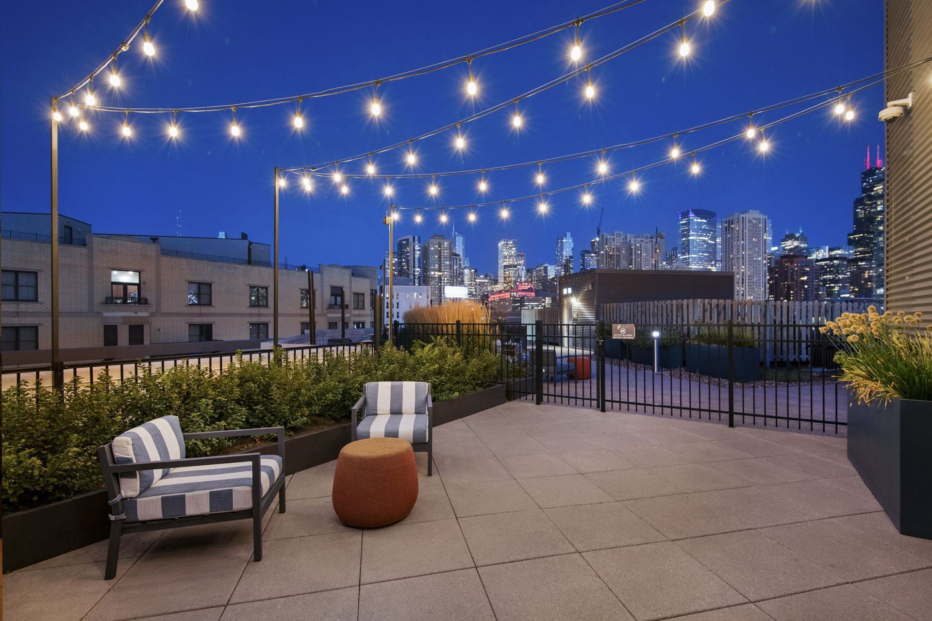 a roof terrace with chairs and a view of the city at night