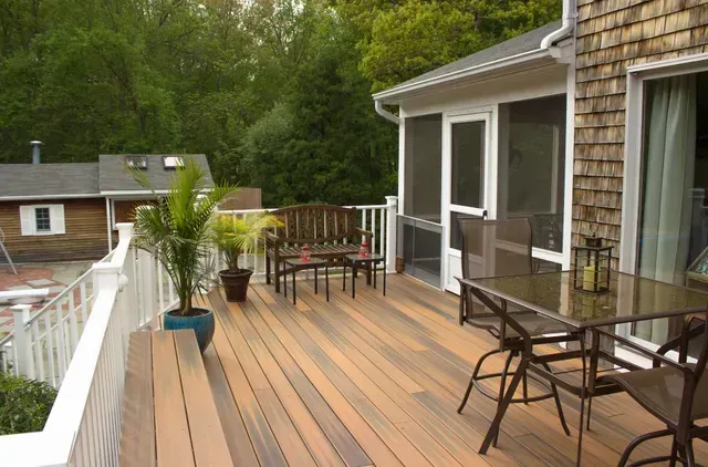 A deck with a table and chairs and a screened in porch