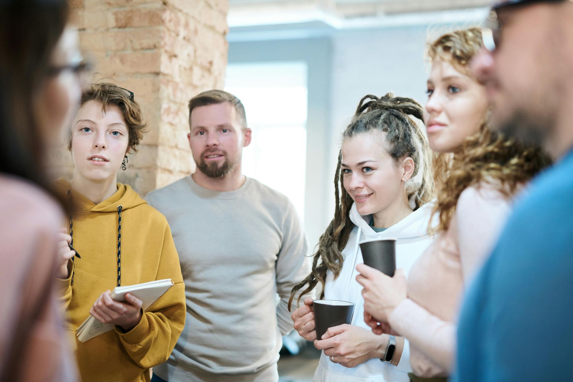A group of people are standing in a circle talking to each other.