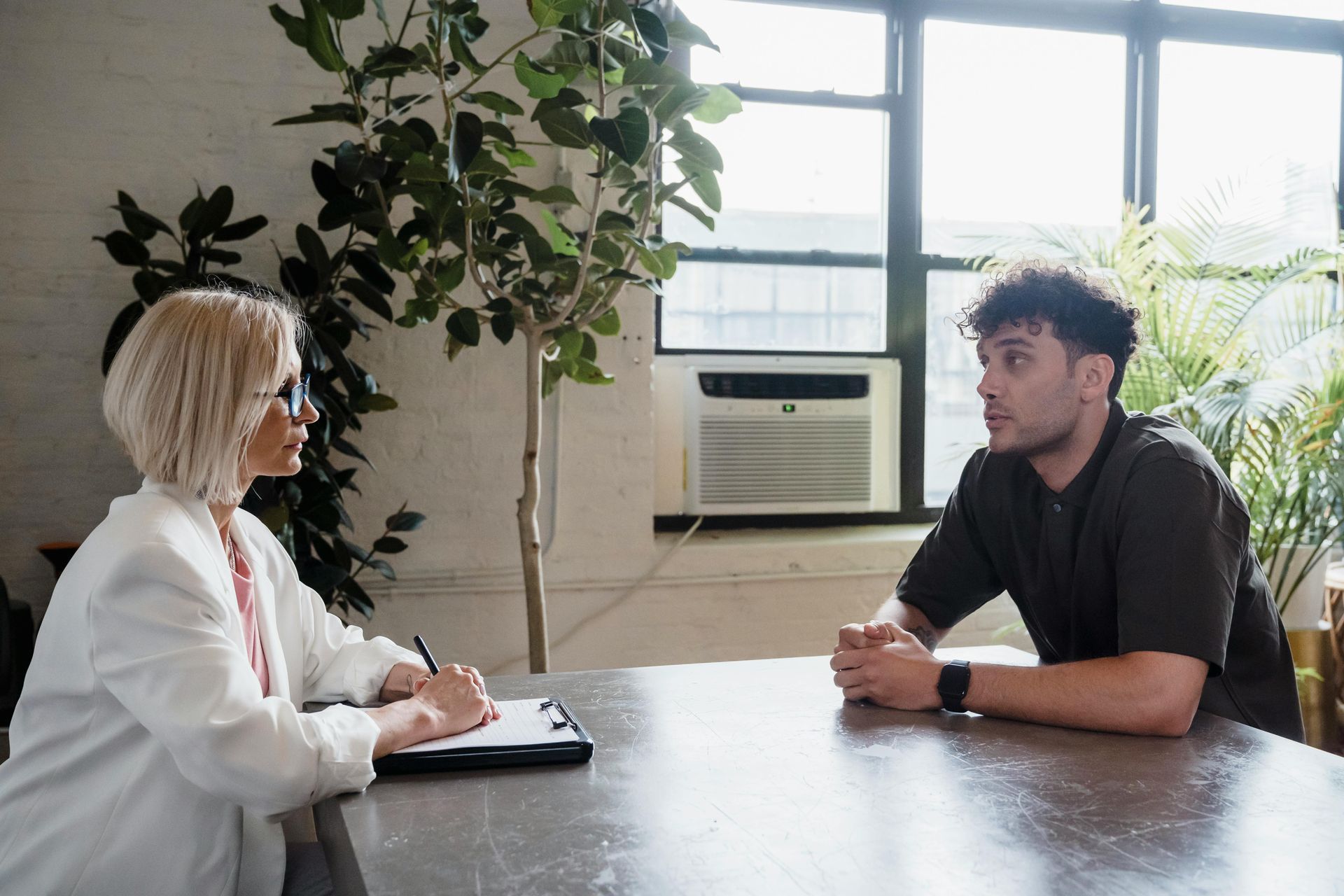 A man and a woman are sitting at a table having a conversation.