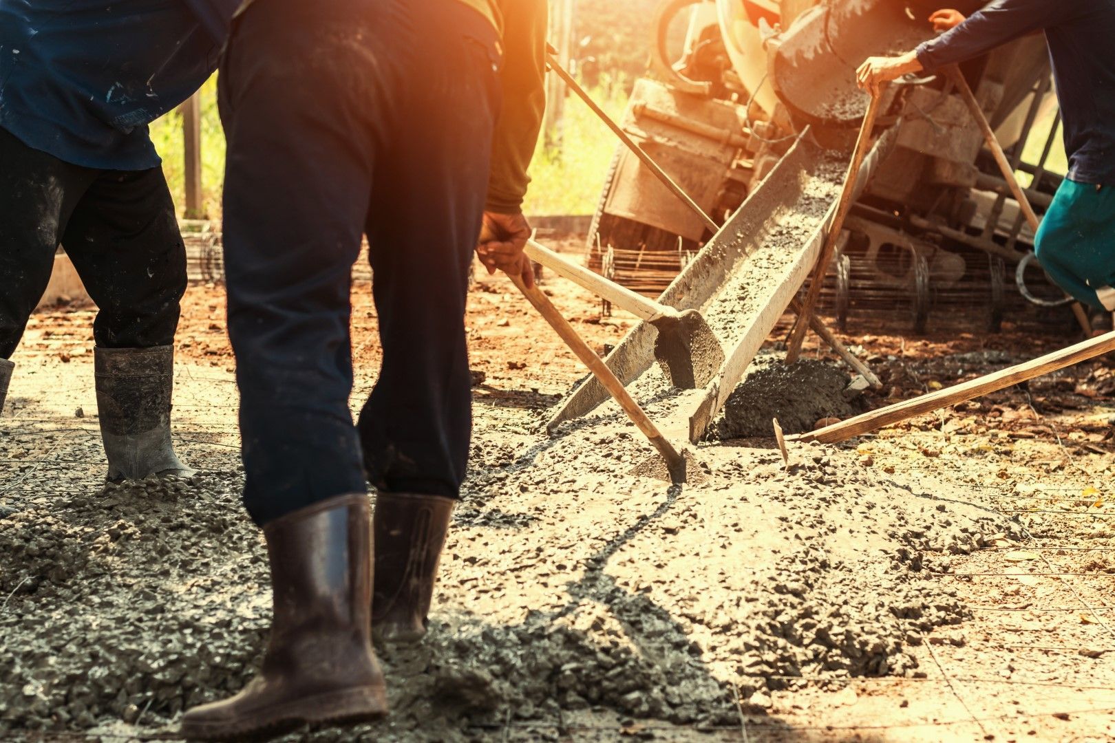 A group of construction workers are pouring concrete on a construction site.