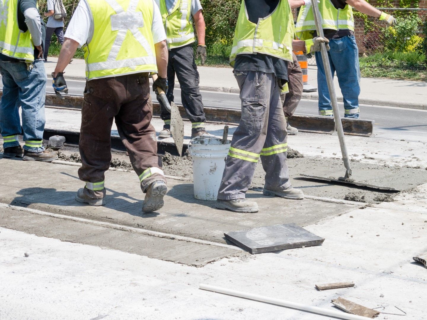 A group of construction workers are working on a road.