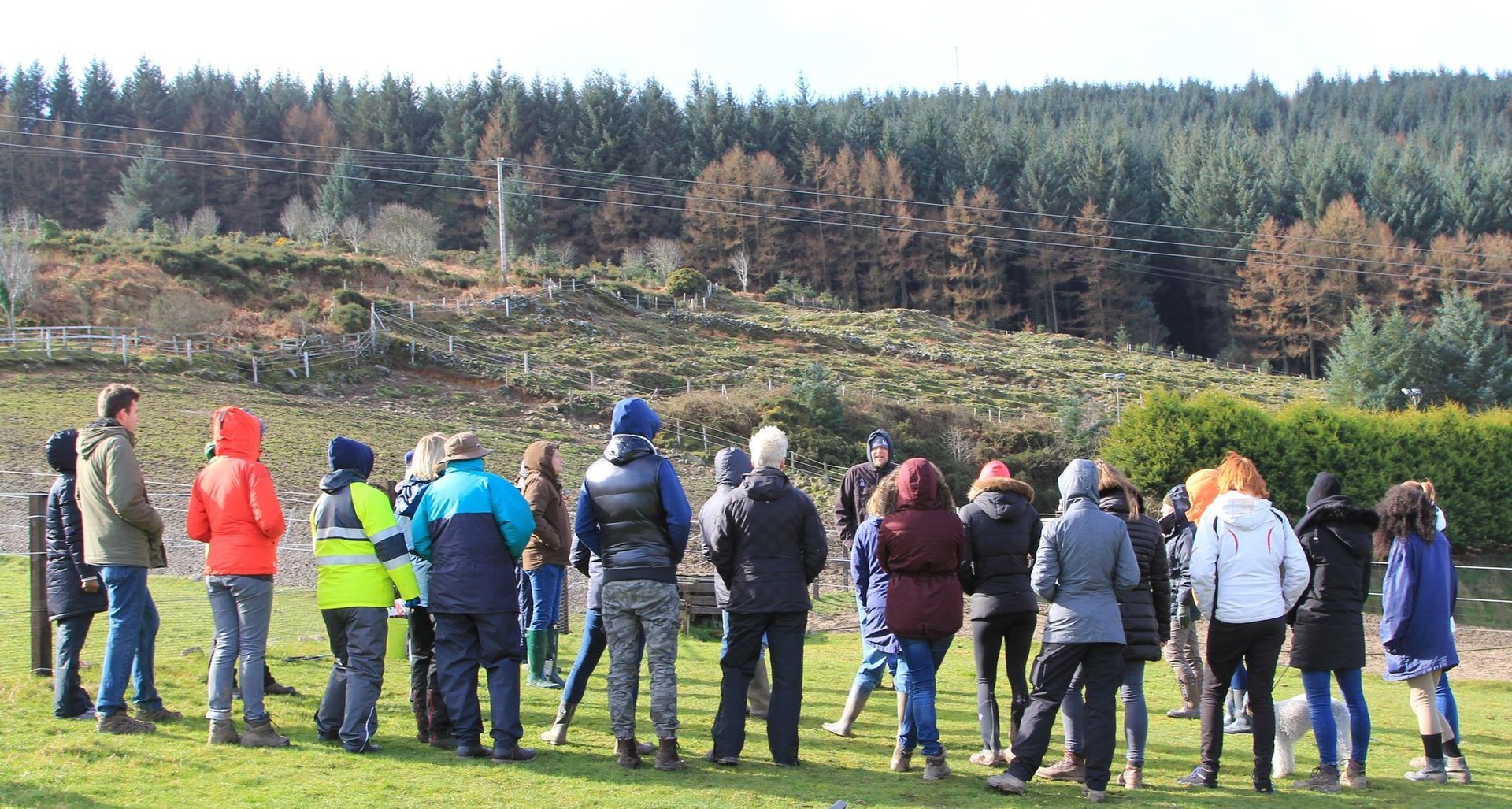 A group of people standing around a dog trainer