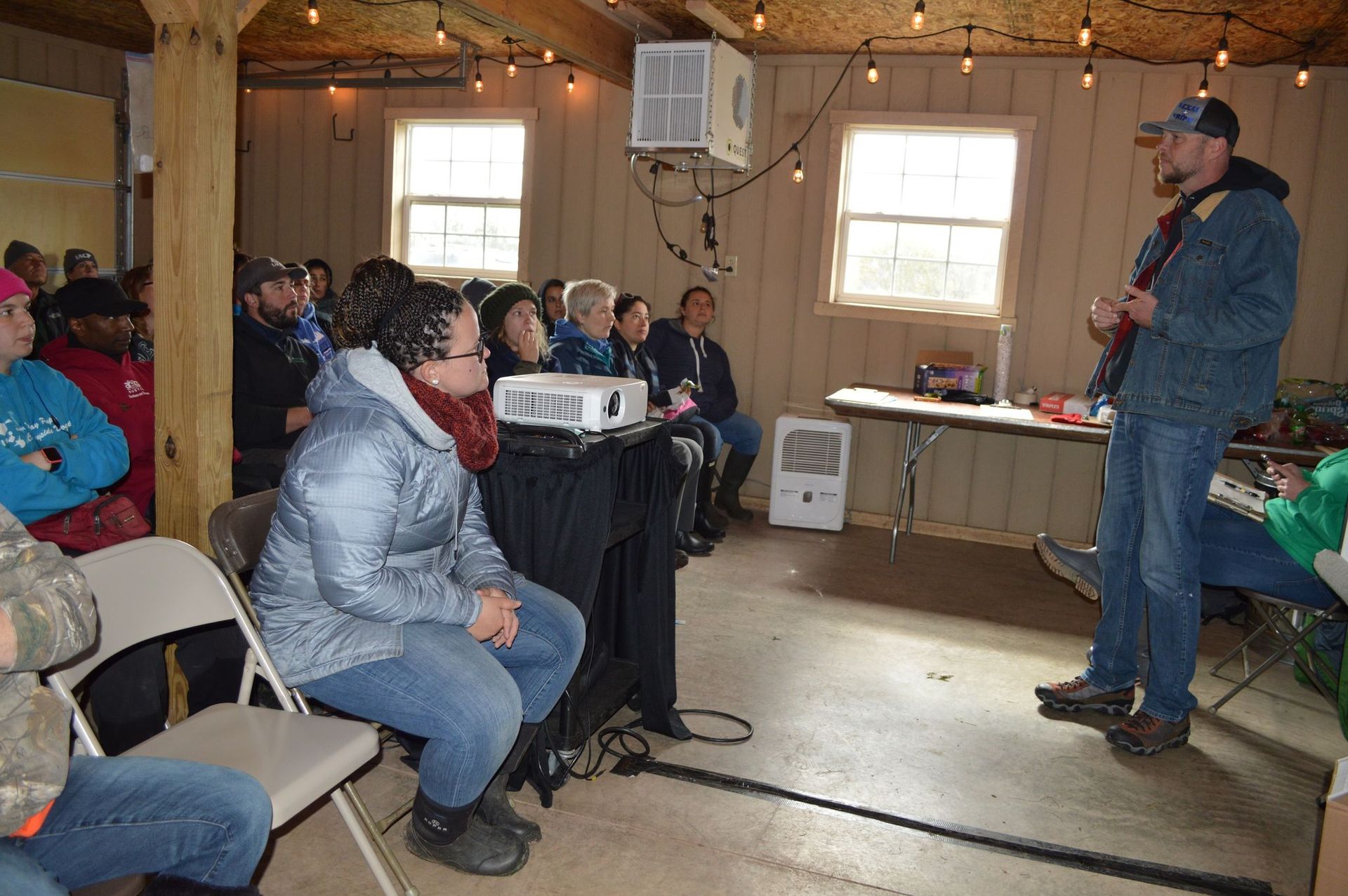 A man standing in front of a group of people talking to them.