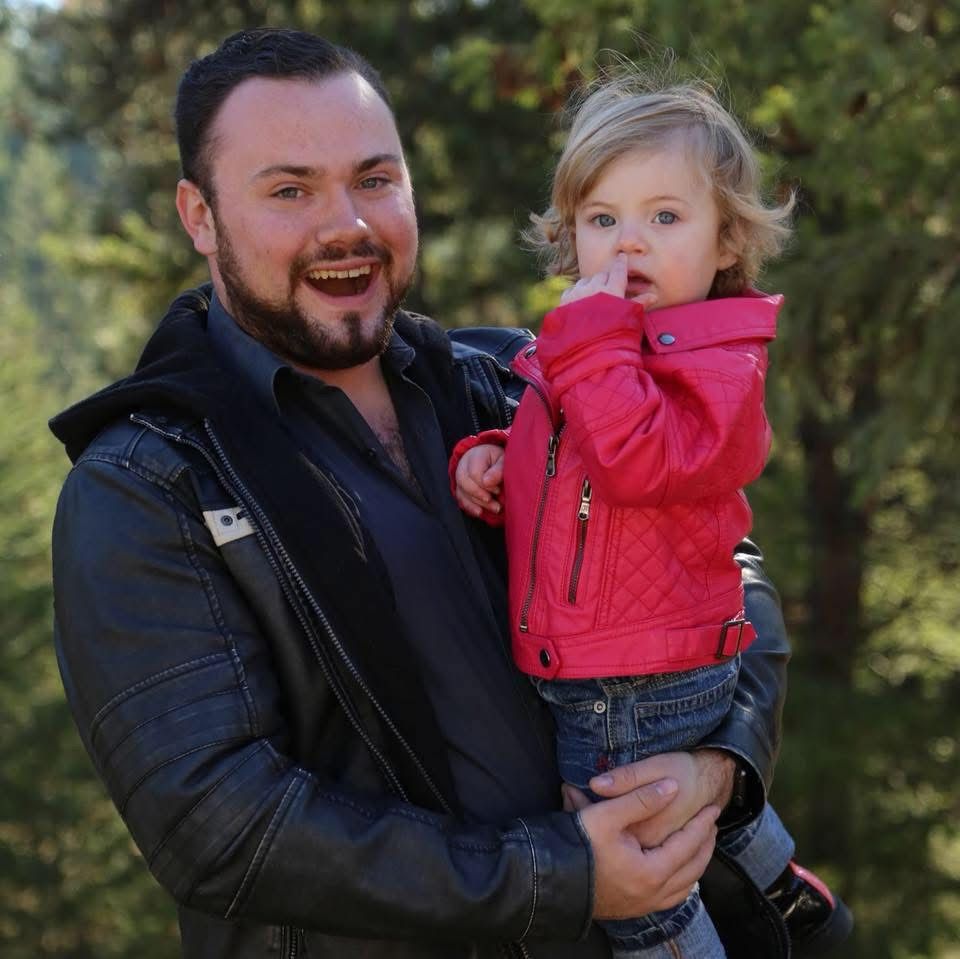 Travis Bertram holding his young daughter
