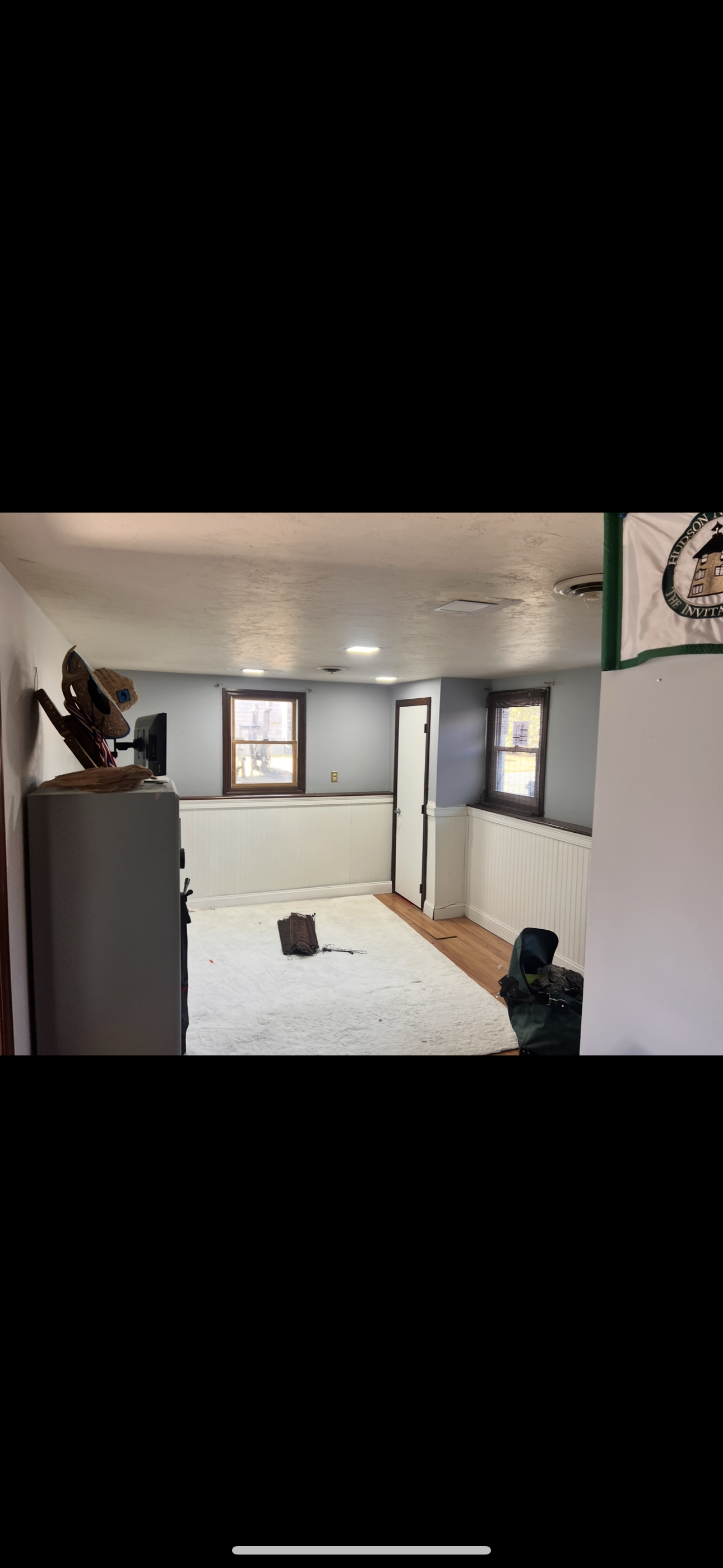 Interior room with windows, a door, and a basketball hoop. The floor is covered with a white tarp.
