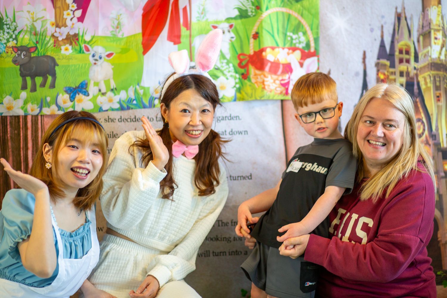 Four people posing: Two women in costumes, one child with glasses, and a woman.