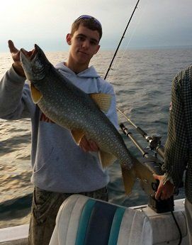 A man holding a large fish on a boat