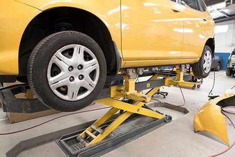 Foreign & Domestics. Cars — Yellow Car on Repair Shop in Spartanburg, SC