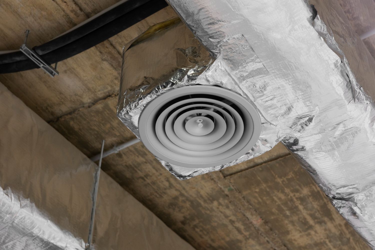 Ceiling air vent with silver ducting and insulation.