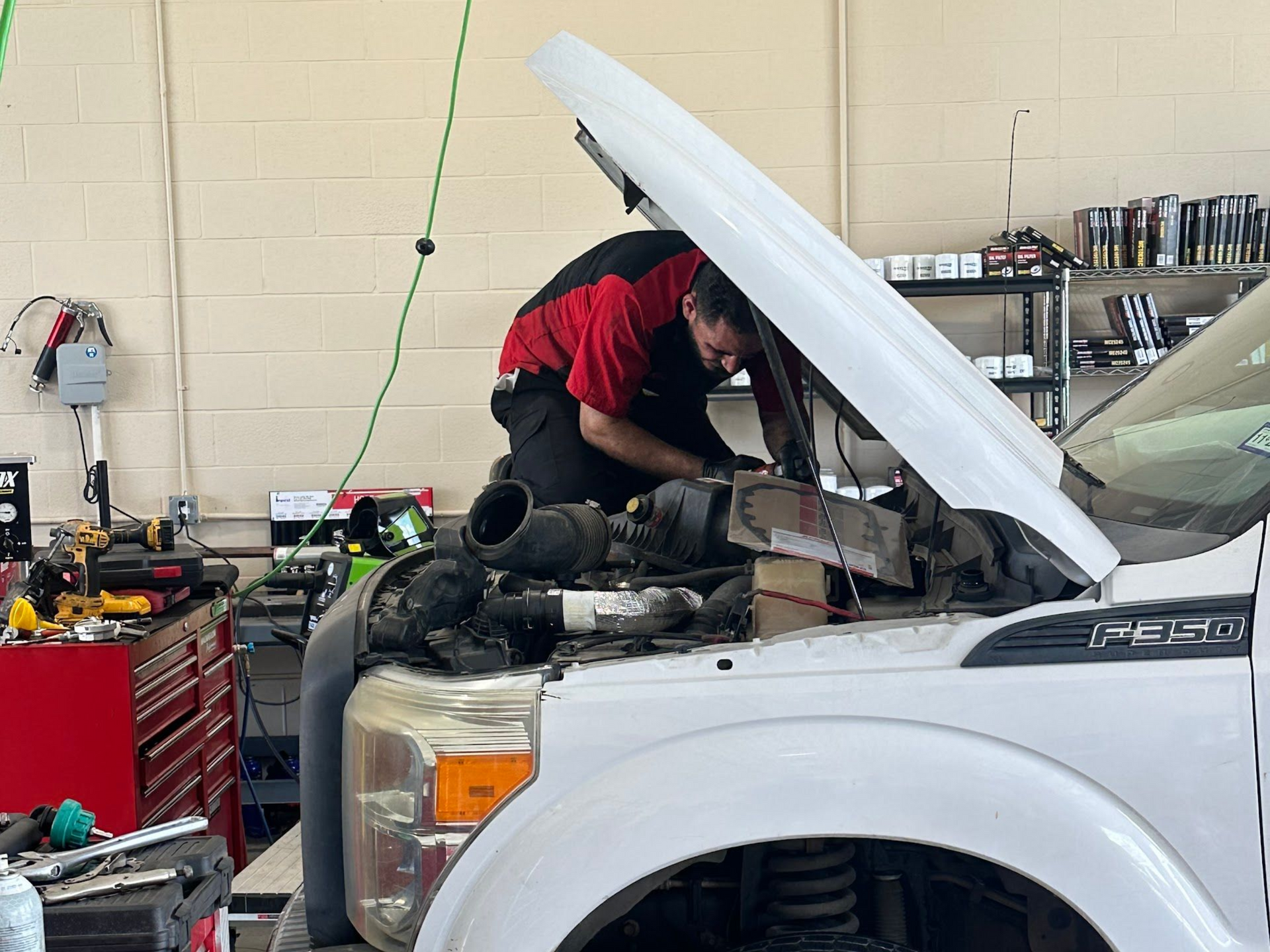 Technician Working Under White Truck Hood | Locals Automotive Repair