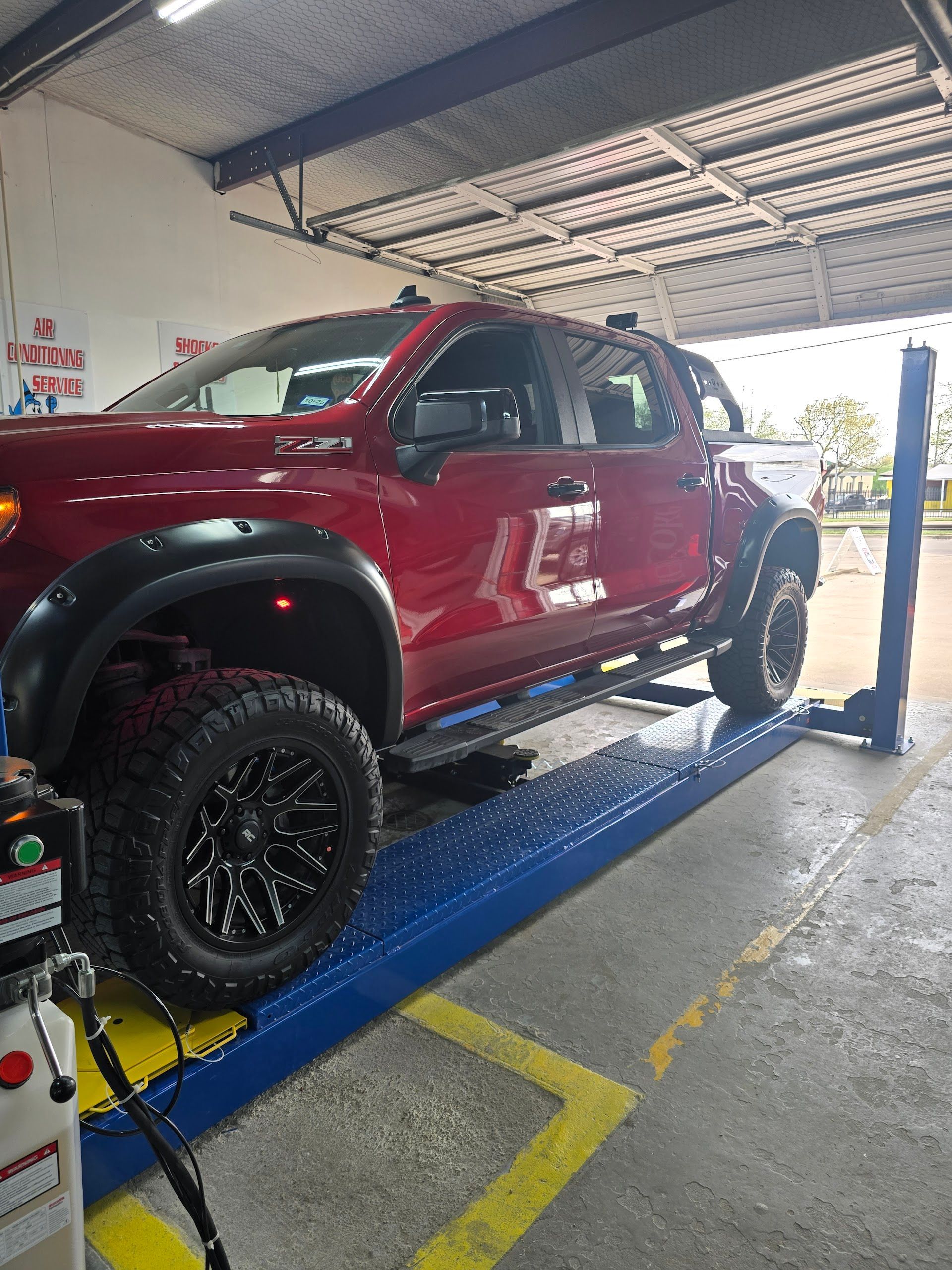 Red Pickup Truck On Service Lift | Locals Automotive Repair