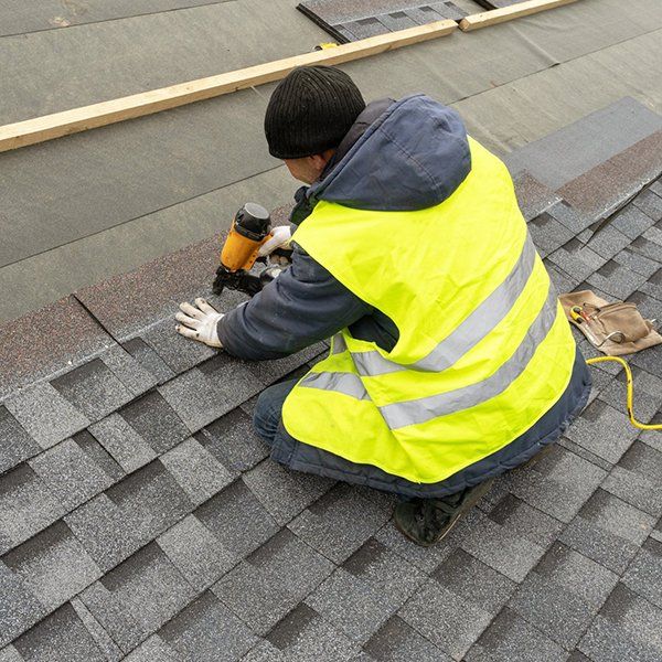 Man Installing Asphalt or Bitumen Shingle Roof — Watsonville, CA — Watsonville Roofing Inc