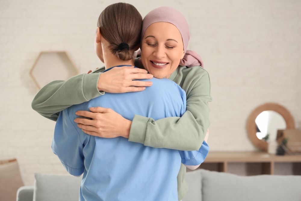 A nurse is helping an elderly woman walk in a kitchen.