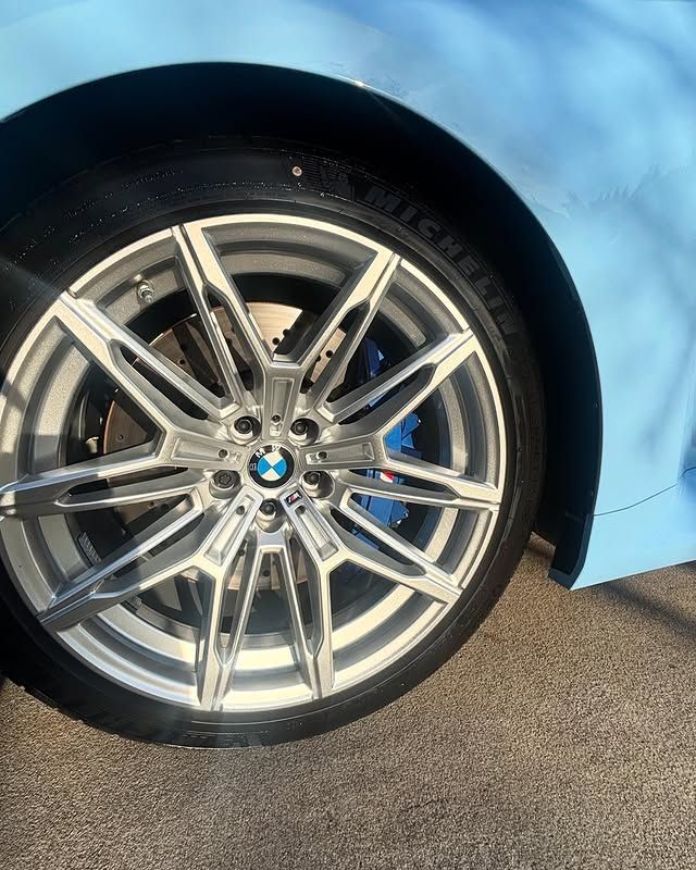 A close up of a bmw wheel with a michelin tire