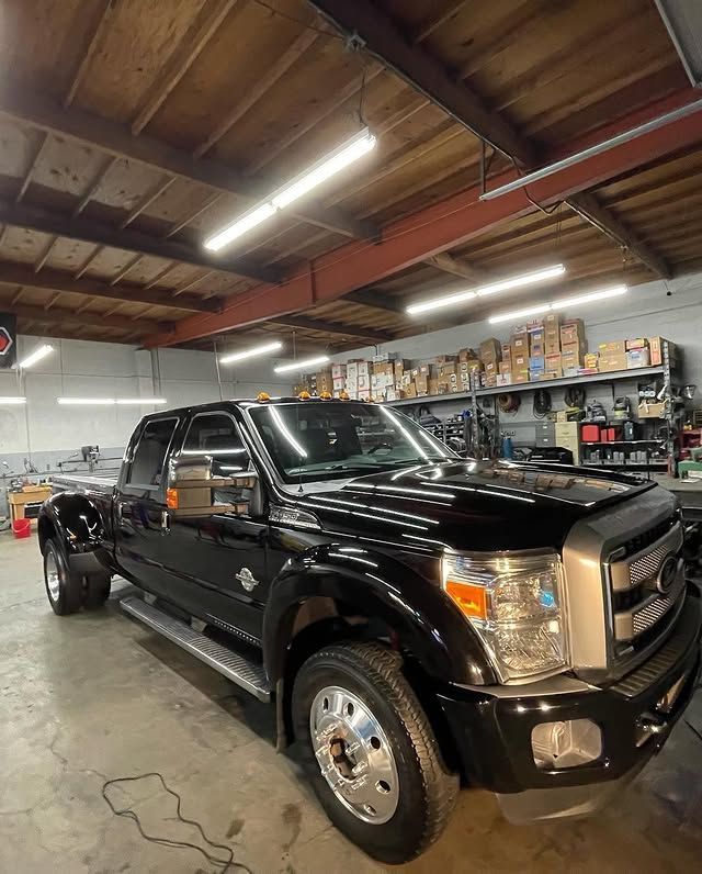 A black pickup truck is parked in a garage.
