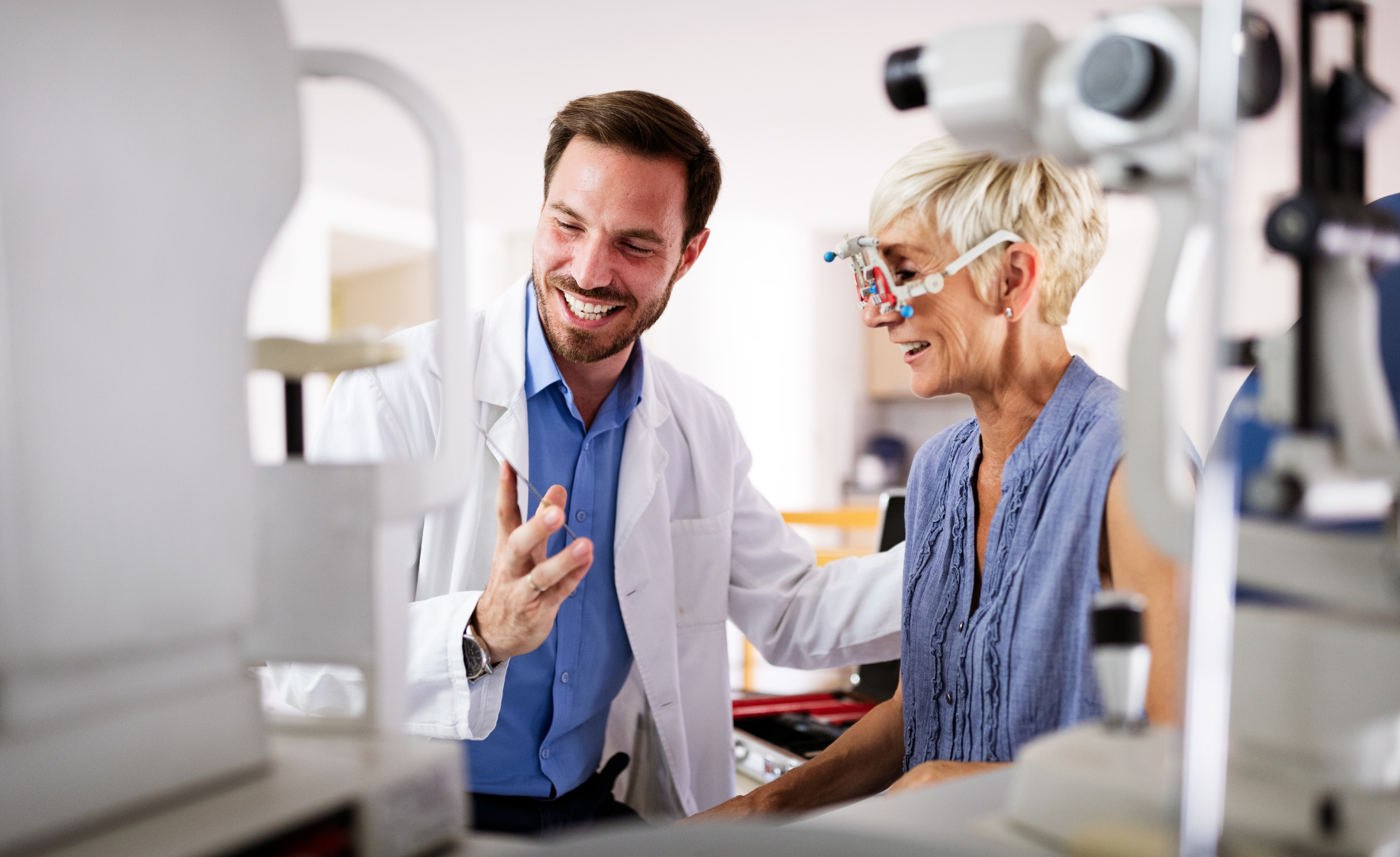 Optometrist assisting patient with a vision test in an examination room.