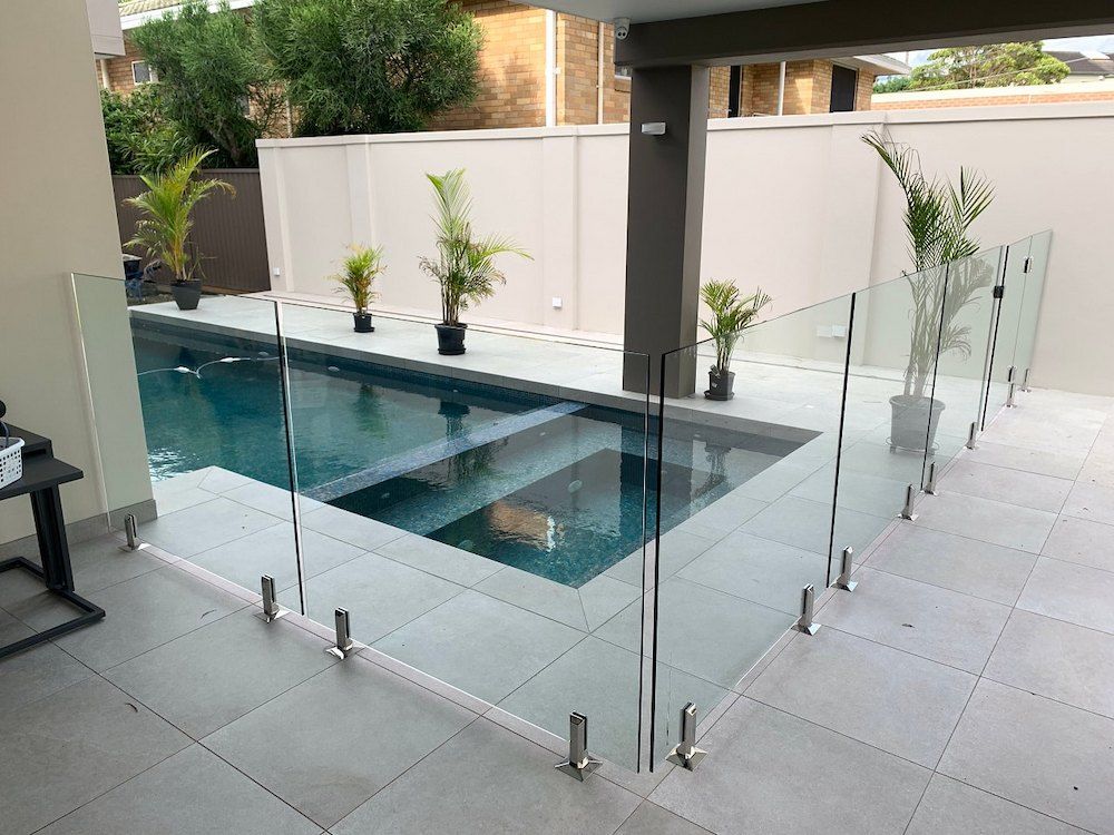 A Swimming Pool With a Glass Fence Around It — All Glass Balustrading Systems in Bondi, NSW