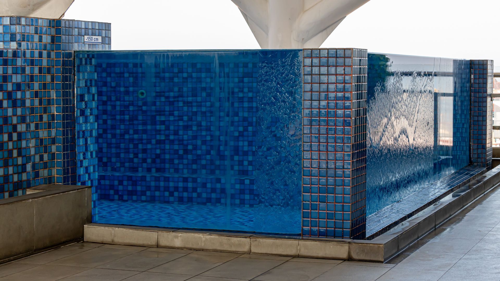 Blue Tiled Water Feature With Water Flowing Down, Set Outdoors — All Glass Balustrading Systems in Wollongong, NSW