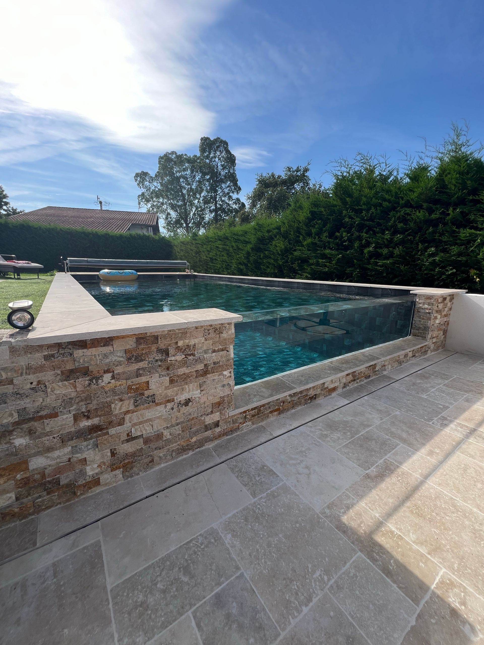 Swimming Pool With a Stone Facade — All Glass Balustrading Systems in Newcastle, NSW