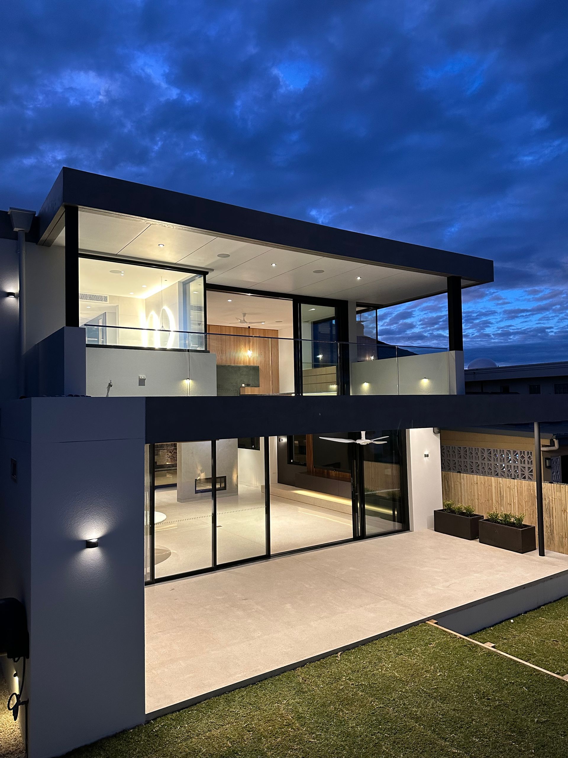 A House At Night With Lights On And Glass Railings — All Glass Balustrading Systems in Coogee, NSW