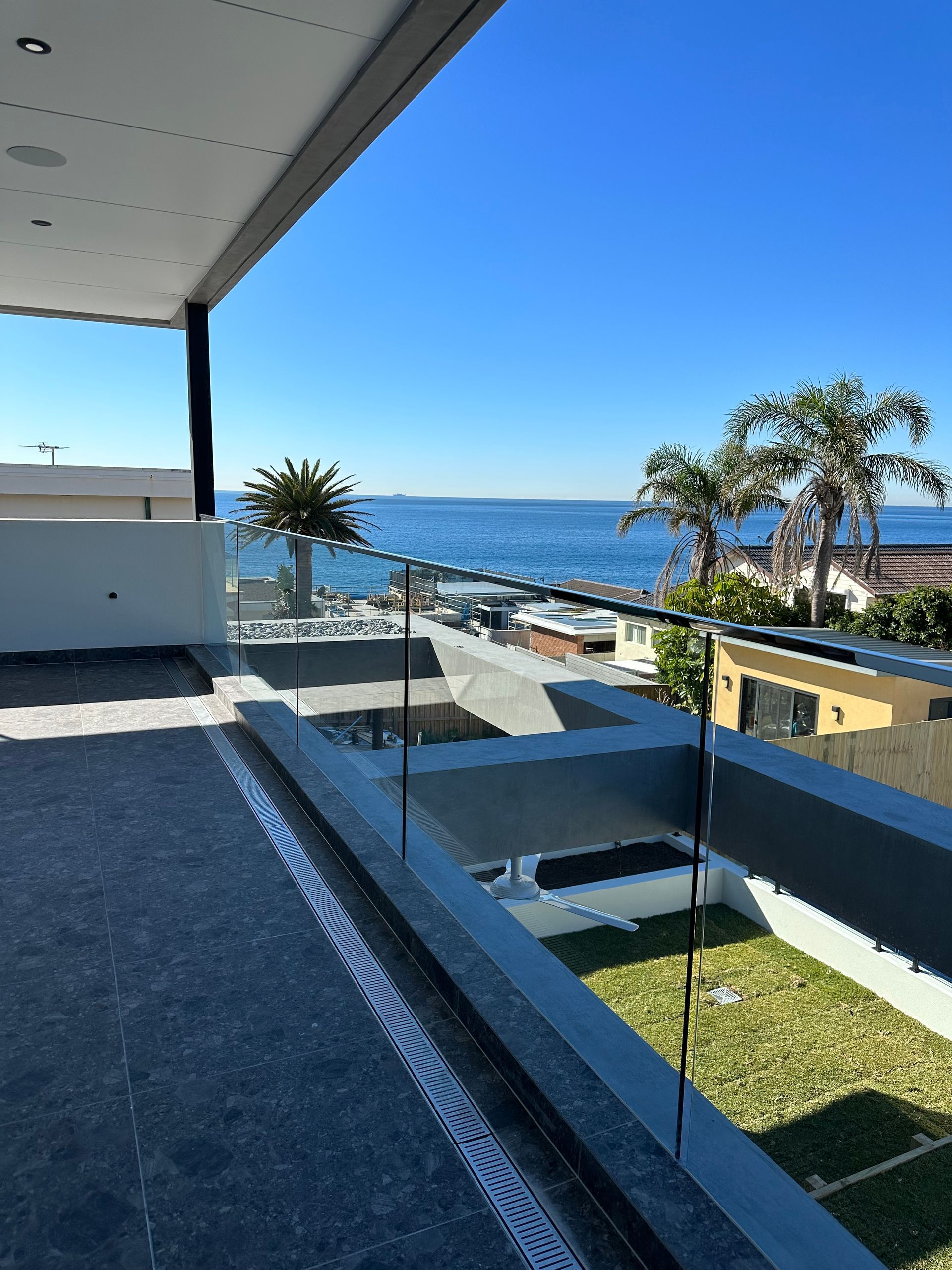 A White Building With a Glass Railing on the Balcony — All Glass Balustrading Systems in Wetherill Park, NSW