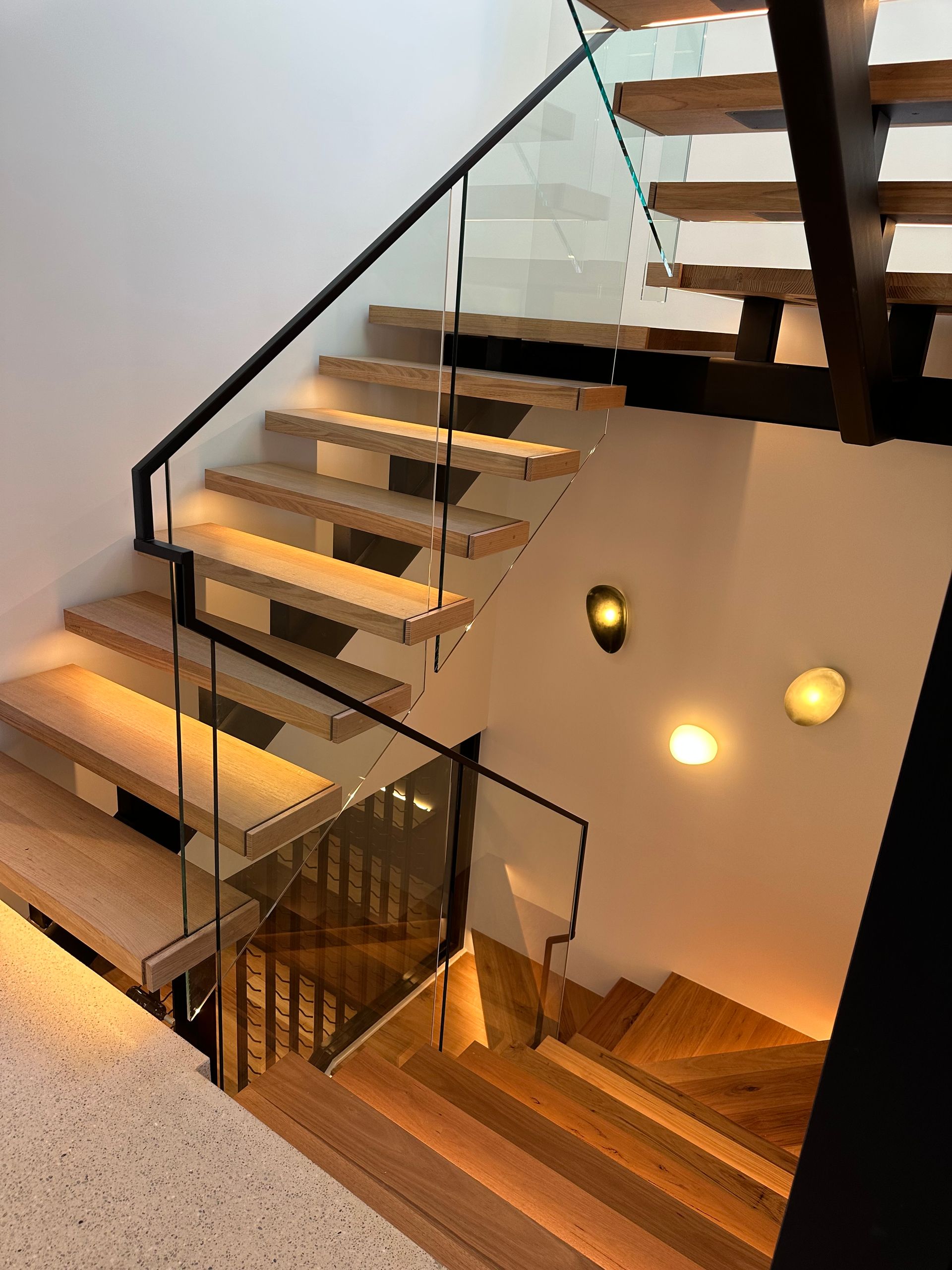 A Wooden Staircase With a Glass Railing in a House — All Glass Balustrading Systems in Wetherill Park, NSW