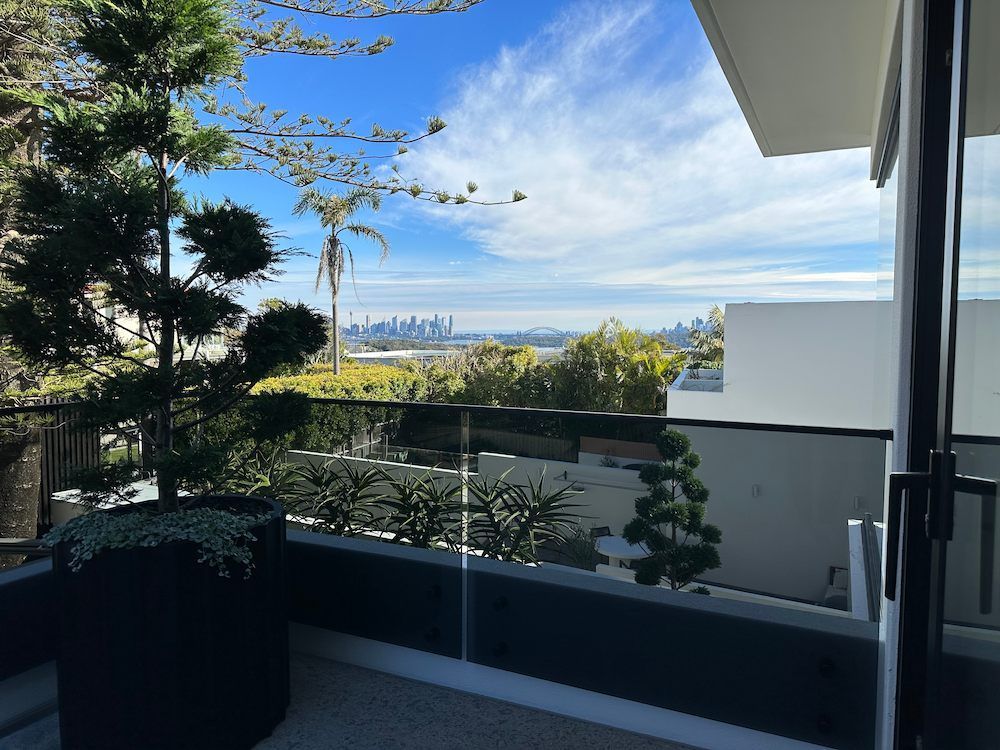 A Balcony With a View of a City and Trees — All Glass Balustrading Systems in Chatswood, NSW